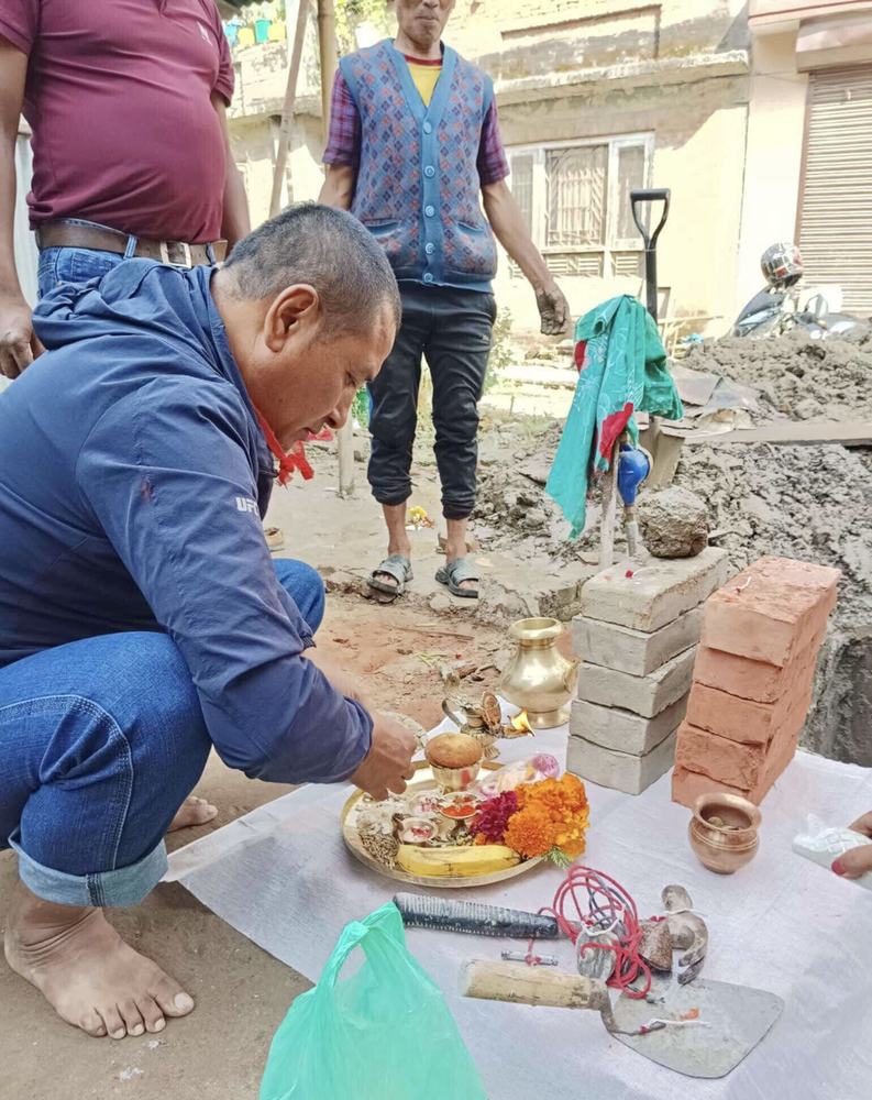 A man making an offering at a construction site