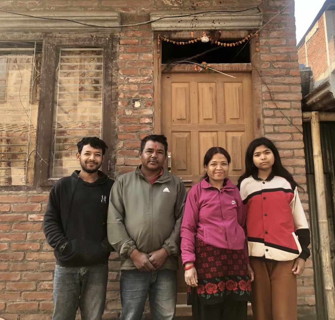 A family standing in front of their new brick home